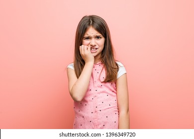 Cute little girl biting fingernails, nervous and very anxious.