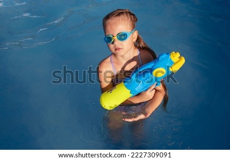 Cute little girl blonde in the pool. High quality photo