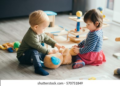 søt liten jente og gutt leker med leker ved hjemmet
