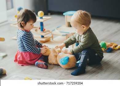 søt liten jente og gutt leker med leker ved hjemmet