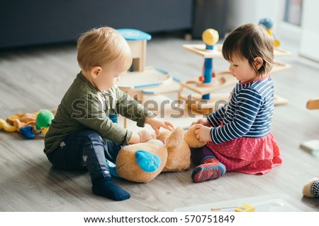 cute little girl and boy playing with toys by the home