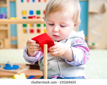cute little girl in the classroom early development plays with bright toys