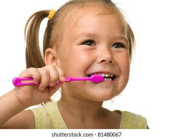 Cute little girl is cleaning teeth using toothbrush, isolated over white