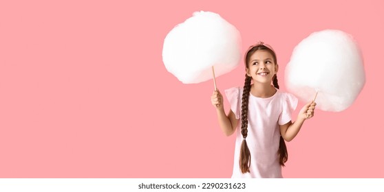 Cute little girl with cotton candy on pink background with space for text