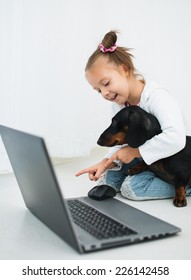 Cute Little Girl  And Dachshund Use Laptop
