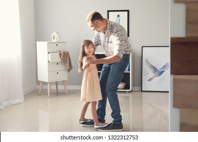 Cute Little Girl Dancing On Her Father's Feet At Home