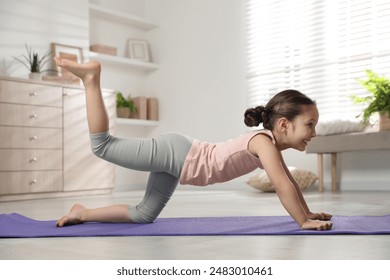 Cute little girl doing exercise at home - Powered by Shutterstock