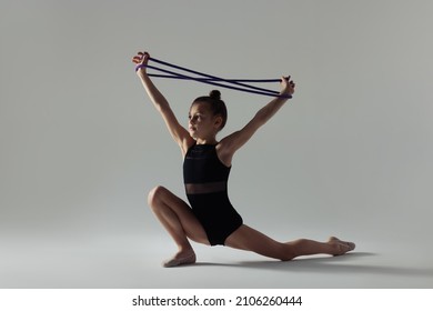 Cute Little Girl Doing Gymnastic Exercise With Rope On White Background