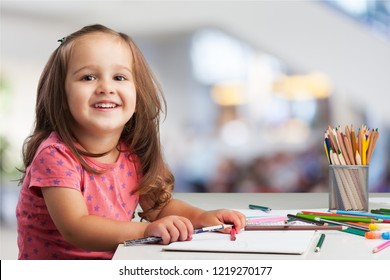 Cute Little Girl Doing Homework, Reading A Book, Coloring Pages, Writing And Painting. Children Paint. Kids Draw. Preschooler With Books At Home. Preschoolers Learn To Write And Read. Creative Toddler