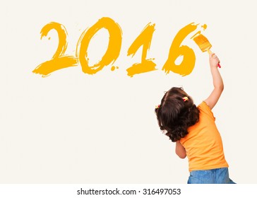 Cute little girl drawing new year 2016 with painting brush on wall background