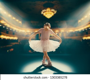 Cute little girl dreaming of becoming a ballerina. Child girl in a pink tutu dancing on the stage. Baby girl is studying ballet.