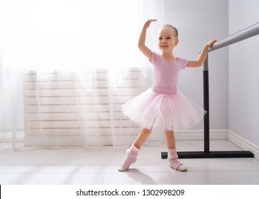 Cute Little Girl Dreams Of Becoming A Ballerina. Child Girl In A Pink Tutu Dancing In A Room. Baby Girl Is Studying Ballet.