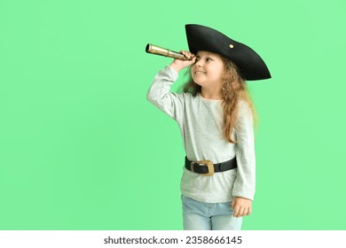 Cute little girl dressed as pirate with spyglass on green background - Powered by Shutterstock