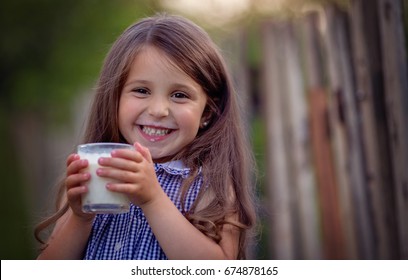 Cute Little Girl Is Drinking Milk In The Countryside