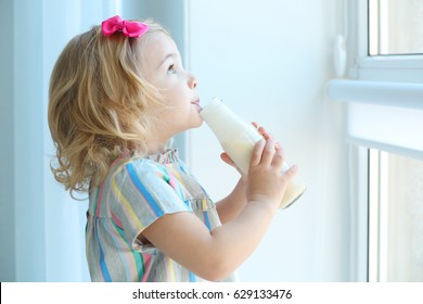 Cute Little Girl Drinking Yogurt At Home