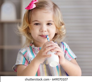 Cute Little Girl Drinking Yogurt At Home