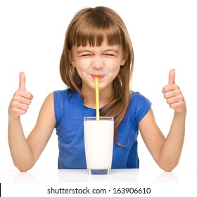 Cute kleine Mädchen trinkt Milch und zeigt Daumenanzeichen mit beiden Händen einzeln auf Weiß