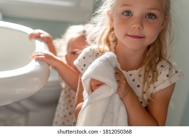 Cute Little Girl Drying Hands On A White Towel In The Bathroom