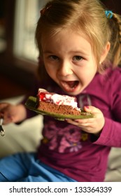 cute little girl eating cake in restaurant