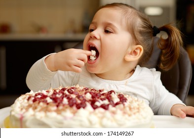 cute little girl eating cake on her birthday