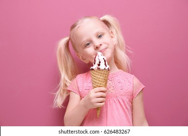 Cute Little Girl Eating Ice Cream On Color Background