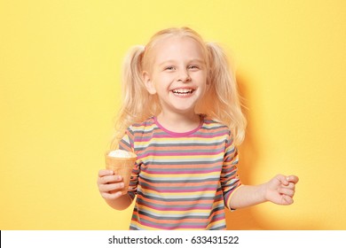 Cute little girl eating ice cream on color background - Powered by Shutterstock