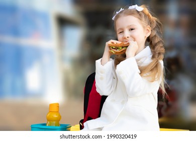 cute little girl eating sandwich during break between classes. healthy unhealthy food for kid. breakfast lunch for children at school. copy space, text - Powered by Shutterstock