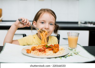 Cute Little Girl Eating Spaghetti With Tomato Sauce And Vegetables For Dinner