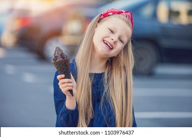 Cute Little Girl Eating Tasty Black Ice Cream Outdoors On Sunny Summer Day