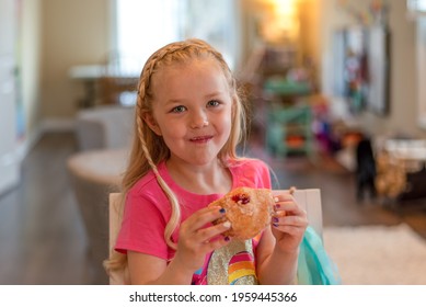 Cute Little Girl Getting Messy Eating A Jelly Donut