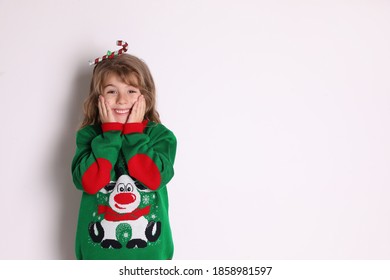 Cute Little Girl In Green Christmas Sweater Smiling Against White Background