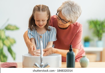 A cute little girl and her grandmother are washing their hands. Protection against infections and viruses.   - Powered by Shutterstock