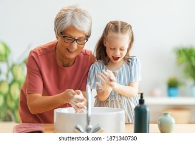 A cute little girl and her grandmother are washing their hands. Protection against infections and viruses.   - Powered by Shutterstock