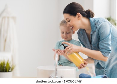 A cute little girl and her mother are washing their hands. Protection against infections and viruses.    - Shutterstock ID 1703663749