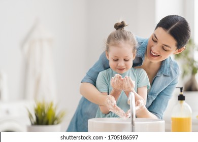 A cute little girl and her mother are washing their hands. Protection against infections and viruses.   
