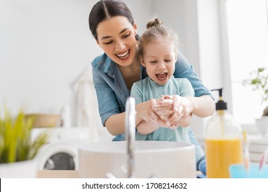 Een schattig klein meisje en haar moeder wassen hun handen. Bescherming tegen infecties en virussen.   