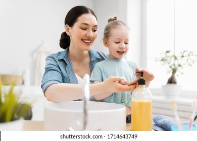 A cute little girl and her mother are washing their hands. Protection against infections and viruses.    - Shutterstock ID 1714643749