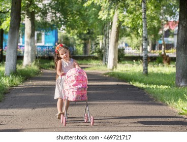 Cute Little Girl With Her Toy Carriage