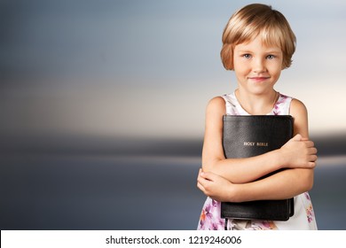 Cute Little Girl Holding Bible On  Background