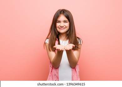 Cute Little Girl Holding Something With Palms, Offering To Camera.