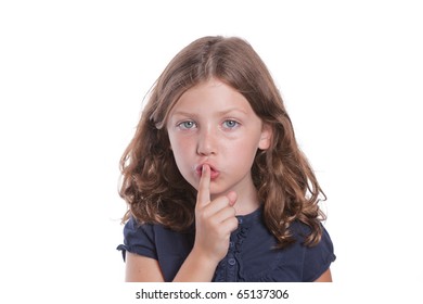 A Cute Little Girl Holds Her Finger Over Her Mouth To Shush