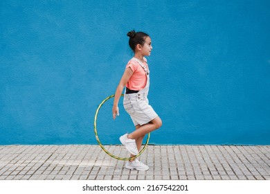 Cute little girl with hula hoop ring - Child having playful time in the city