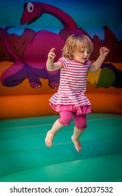 Cute little girl jumping inside the inflatable bouncy castle - Shutterstock ID 612037532