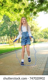 Cute Little Girl Jumping Rope In Park