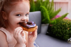 Cute Little Girl, Kid Eating The Chocolate Glazed Donut