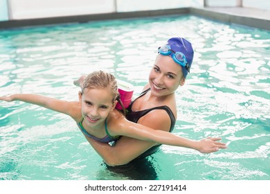 Cute little girl learning to swim with coach at the leisure center - Powered by Shutterstock