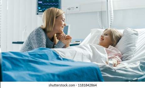 Cute Little Girl Lies on a Bed in the Children's Hospital, Her Mother Sits Beside, They Talk. Modern Pediatric Ward. - Powered by Shutterstock