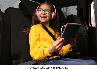 Cute Little Girl Listening To Audiobook In Car