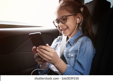 Cute Little Girl Listening To Audiobook In Car