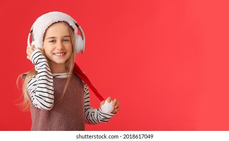 Cute Little Girl Listening To Christmas Music On Color Background